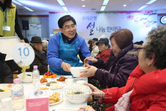 이광구 우리은행장(가운데)이 12일 서울 중구 유락종합사회복지관에 열린 설 나눔 한마당 잔치에 참석해 떡국을 배식하고 있다.